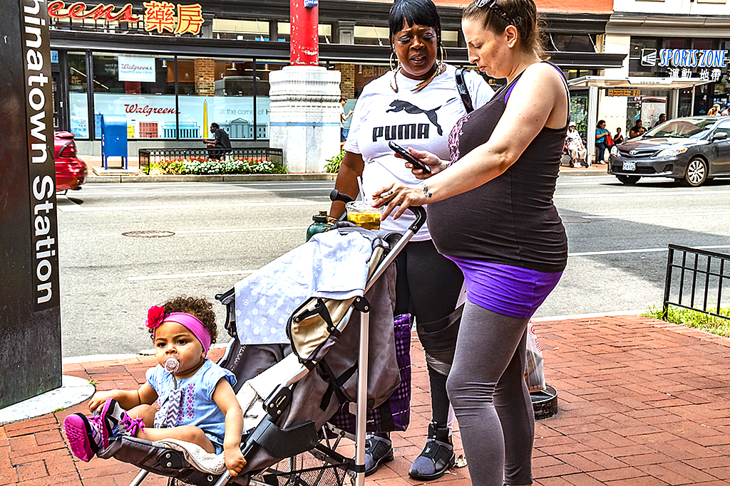 Pregnant woman pushing a stroller with infant--Washington