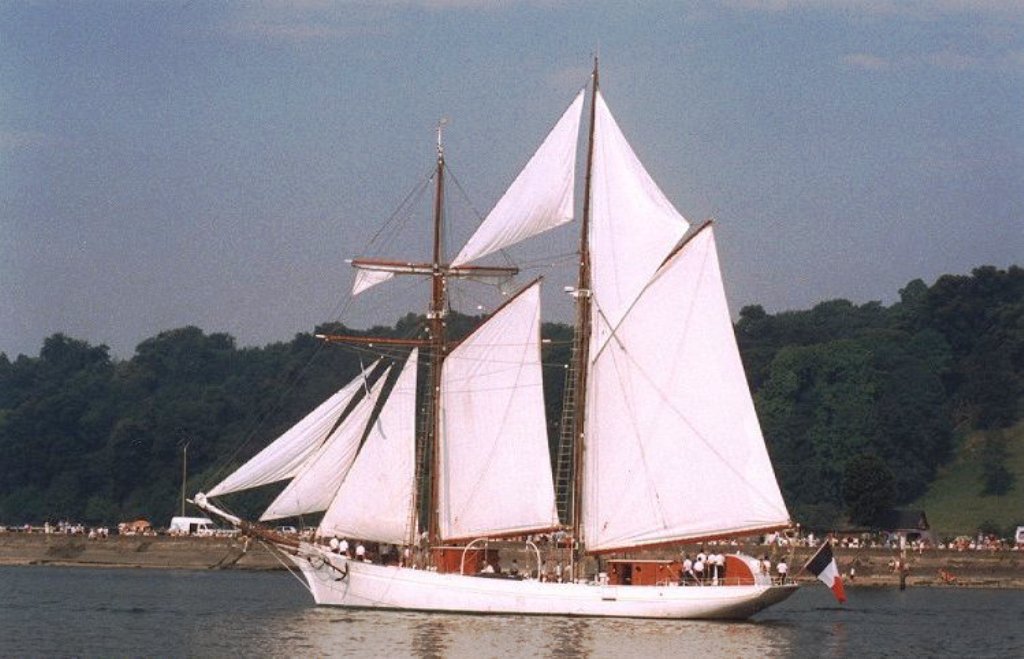 The sail training schooner Étoile of the French navy sails down the Seine river between Rouen and La Bouille, a small town downstream from Rouen (July 1999). Picture taken during the parade on the Seine river on the occasion of the Armada Rouen 1999 (Armada du siècle)