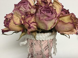 A closeup of a cornucopia of dried pink roses.