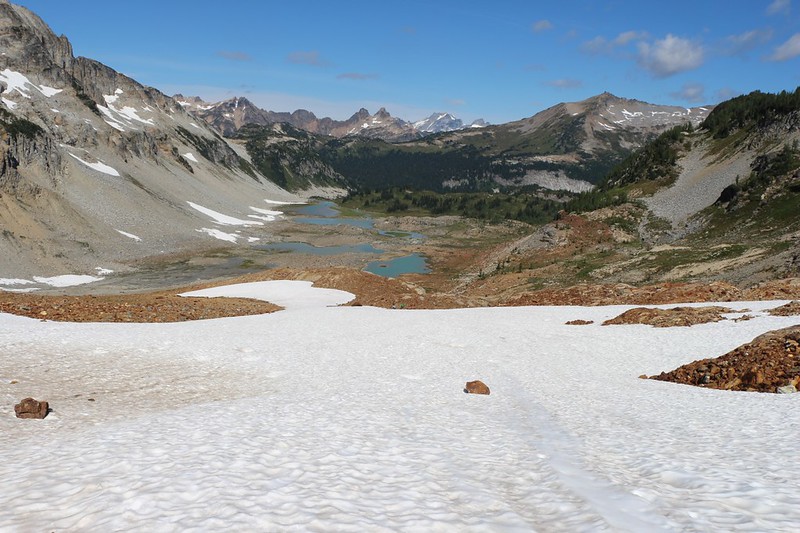 Looking back down at the Upper Lyman Lakes from the snowfield on the way to Spider Gap