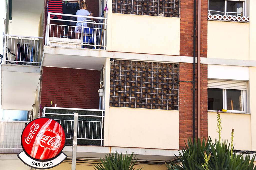 Woman hanging laundry on balcony--Martorell