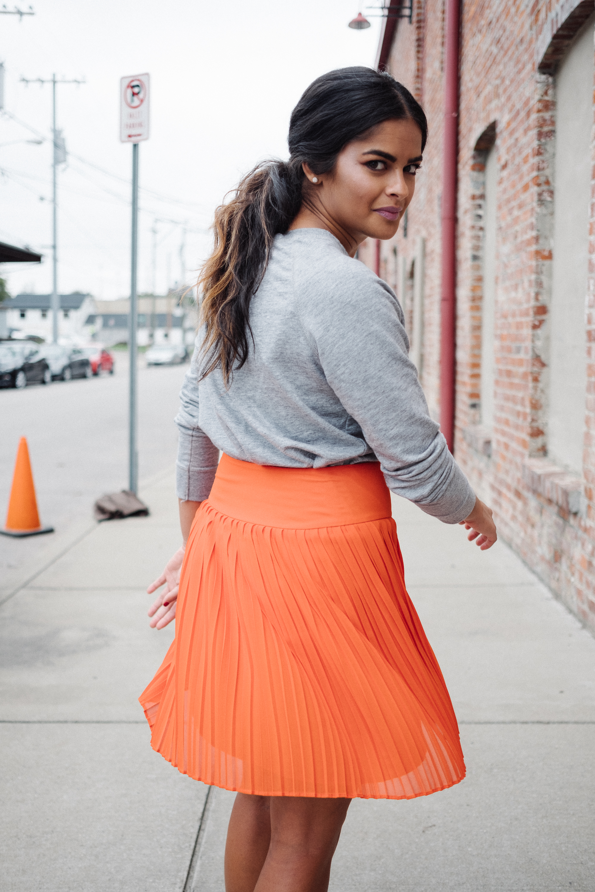 Priya the Blog, Nashville style blog, orange pleated skirt, ban.do I Like Sports pin, white Superga trainers, gray crewneck sweatshirt, girly sporty outfit