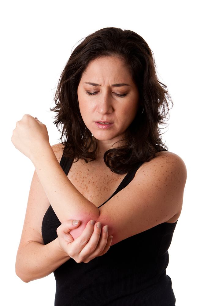 woman in pain holding elbow