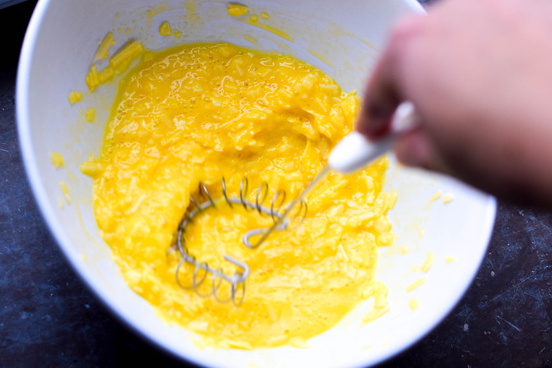 Ägg vispas med parmesanost i en vit skål
