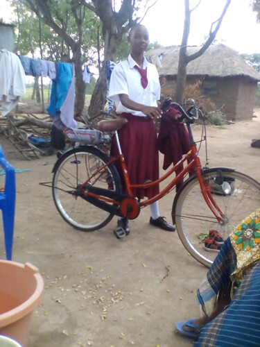 A proud daughter riding a bicycle purchased through the sale of chicks (photo credit: ILRI)