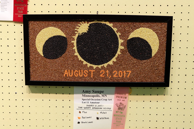 a long, short framed artwork with a three versions of the eclipse, including a ring in the center, and August 21, 2017 at the bottom