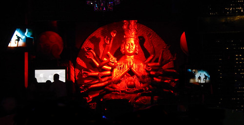 Red lights highlight a multi-armed godess in a Club in Puerto Vallarta
