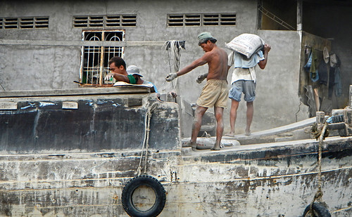 Cement workers on a barge on the Mekong River in Vietnam