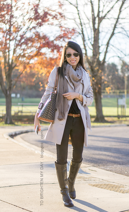 trench coat, plaid scarf, black twist front top, brown belt, gold watch, black jeans, black riding boots, monogrammed tote