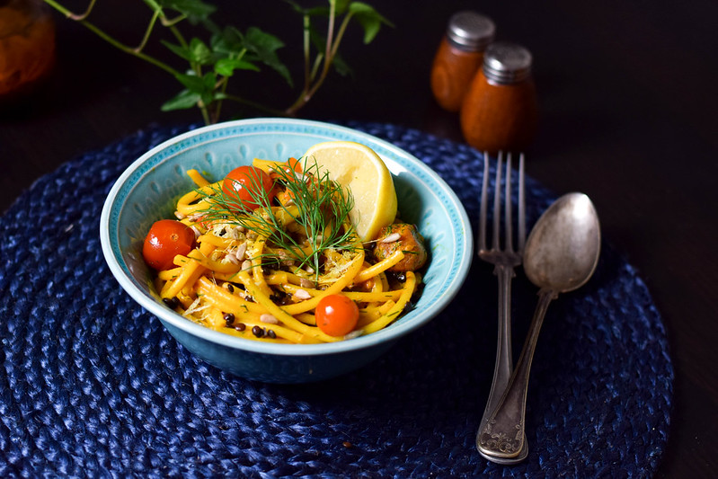 Vegansk tomat- och saffranspasta med dill i en turkos skål på ett mörkblått underlag