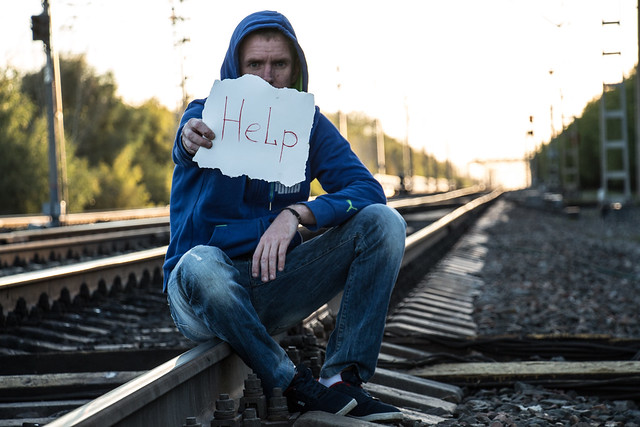 Addict sitting on the railroad tracks