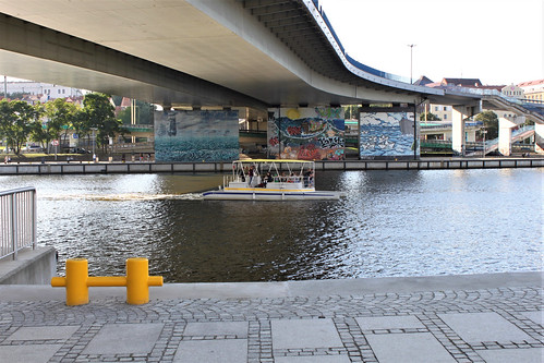 graffiti on bridge and boat on river