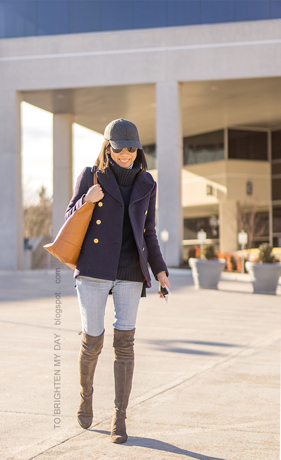 gray wool baseball cap, navy pea coat, striped turtleneck, navy turtleneck sweater tunic, cognac brown tote, lightwash jeans, gray suede over the knee boots