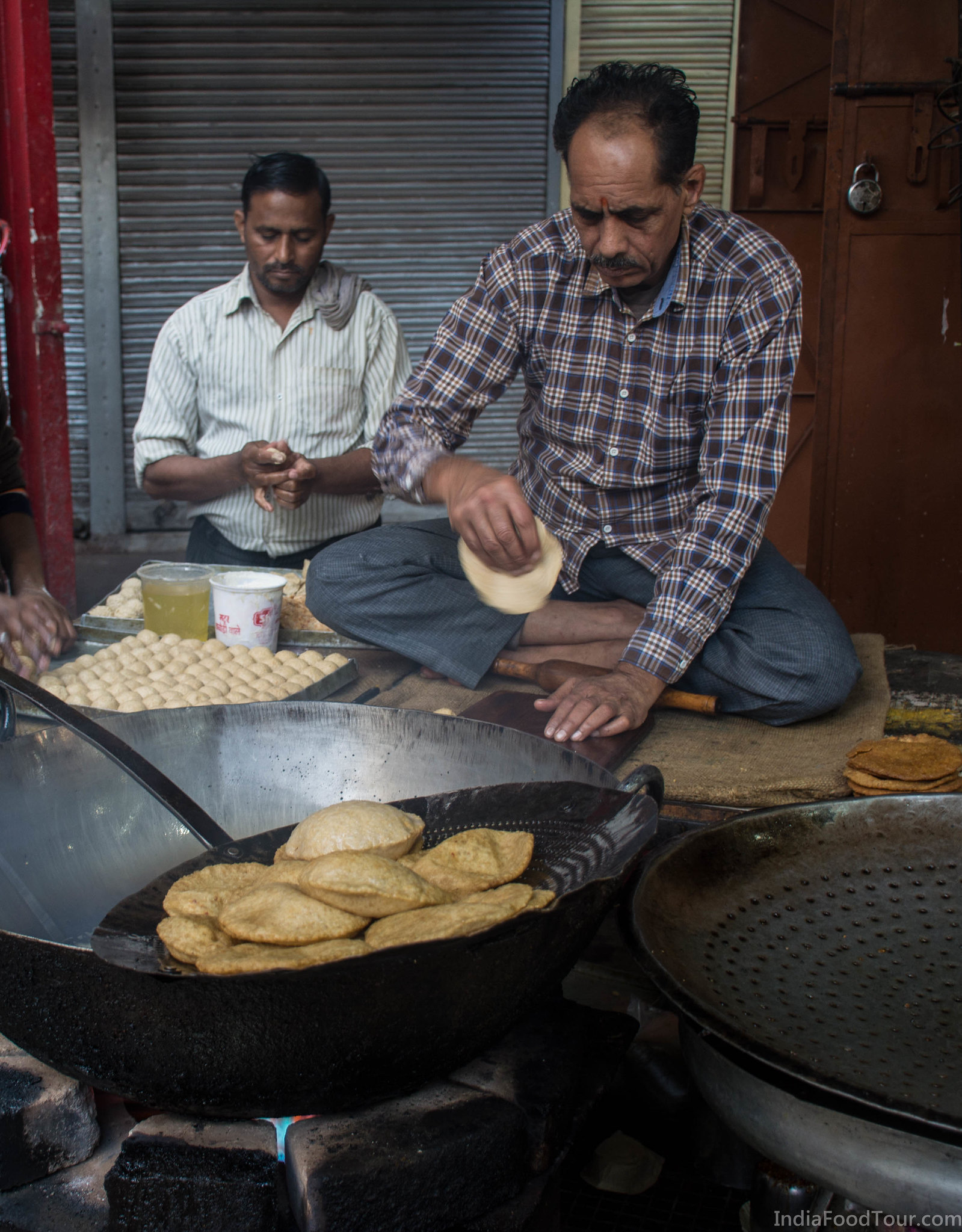 Workers in a food shop cooking Puri