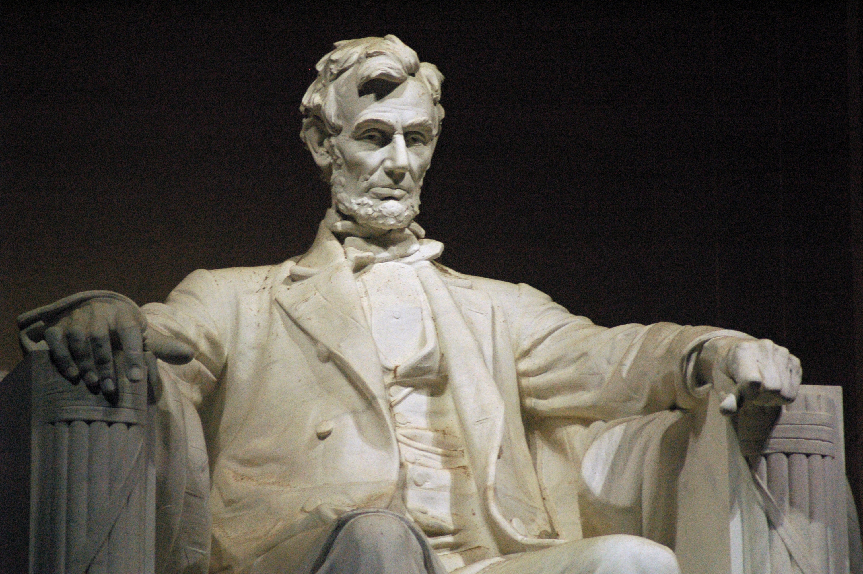 Statue of Abraham Lincoln sitting in contemplation in the central hall of the Lincoln Memorial in Washington, D.C.. The statue was carved by the Piccirilli Brothers under the supervision of the sculptor, Daniel Chester French, and took four years to complete. The statue, originally intended to be only 10 feet (3.0 m) tall, was, on further consideration, enlarged so that it finally stood 19 feet (5.8 m) tall from head to foot, the scale being such that if Lincoln were standing, he would be 28 feet (8.5 m) tall. Lincoln's arms rest on representations of Roman fasces, a subtle touch that associates the statue with the Augustan (and imperial) theme (obelisk and funerary monuments) of the Washington Mall. The statue is discretely bordered by two pilasters, one on each side. Between these pilasters, and above Lincoln's head, is engraved an epitaph of Lincoln by Royal Cortissoz.