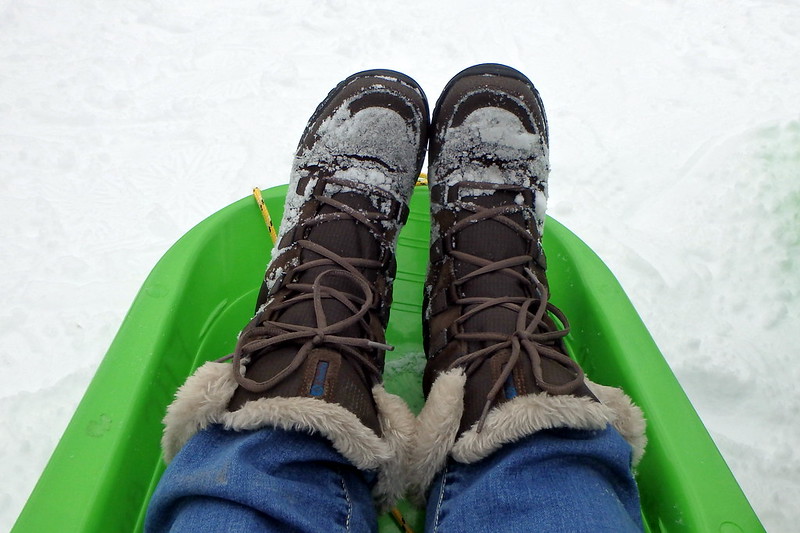 Selfie that is simply two boots in a bright green sled.