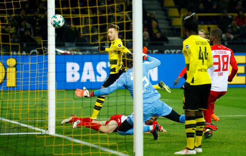 Útočník Borussie Dortmund Marco Reus (v pozadí) střílí úvodní gól zápasu 24. kola německé Bundesligy proti Augsburgu (1:1)
