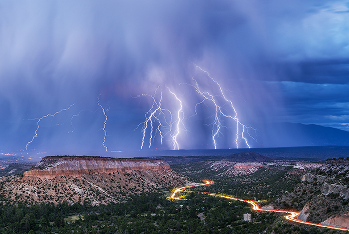 Lightning flashes and rain falls in the valley between Los Alamos and the Sangre de Cristo mountains.