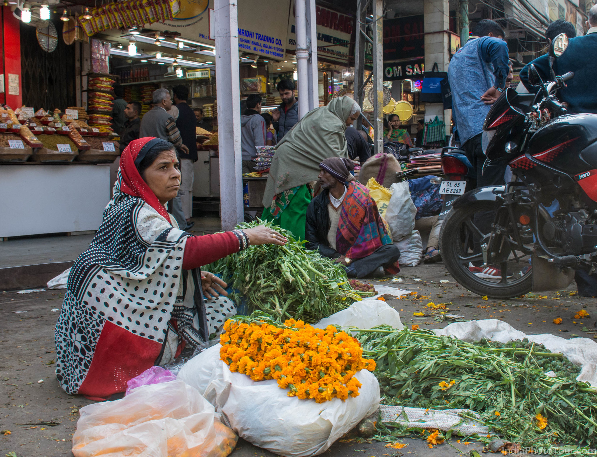 A vendor selling marigold flowers and cannabis plant used in a local festival