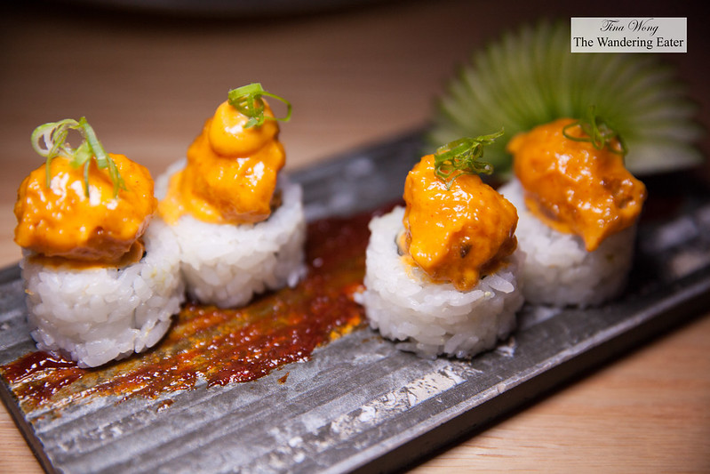 Vegetarian maki roll topped with fried vegetable and spicy sauce