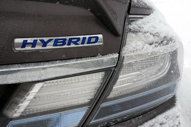 closeup of the word Hybrid on the back of a dark gray car