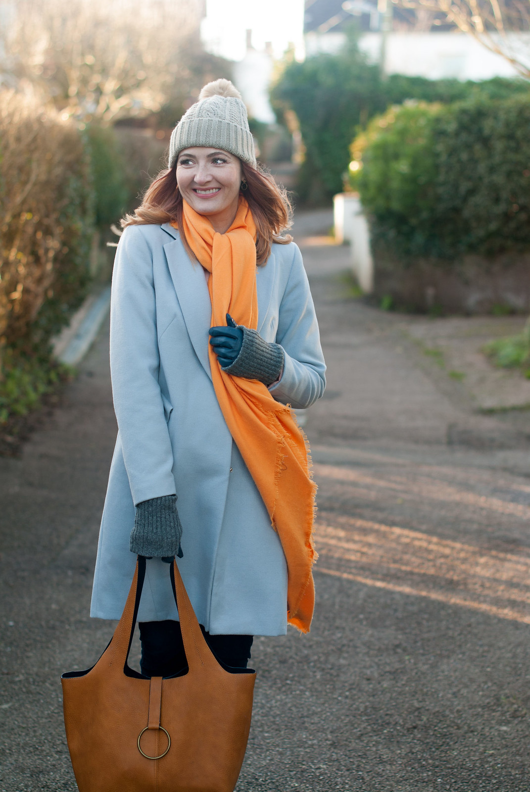 Bold brights winter style: Tangering orange scarf with pale grey duster coat, blue velvet trousers, grey flatforms and taupe pom pom beanie | Not Dressed As Lamb, over 40 style