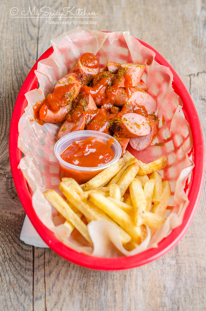 Basket of currywurst, fries and sauce.