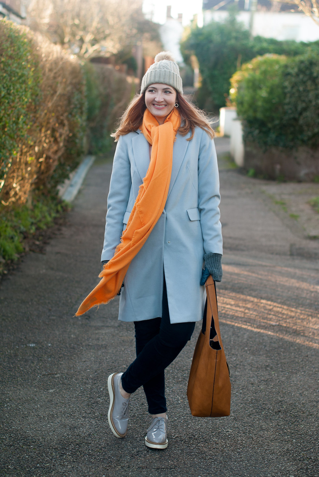 Bold brights winter style: Tangering orange scarf with pale grey duster coat, blue velvet trousers, grey flatforms and taupe pom pom beanie | Not Dressed As Lamb, over 40 style