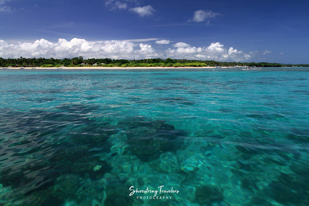 aquamarine waters off a white sand beach at Maniwaya Island, Marinduque
