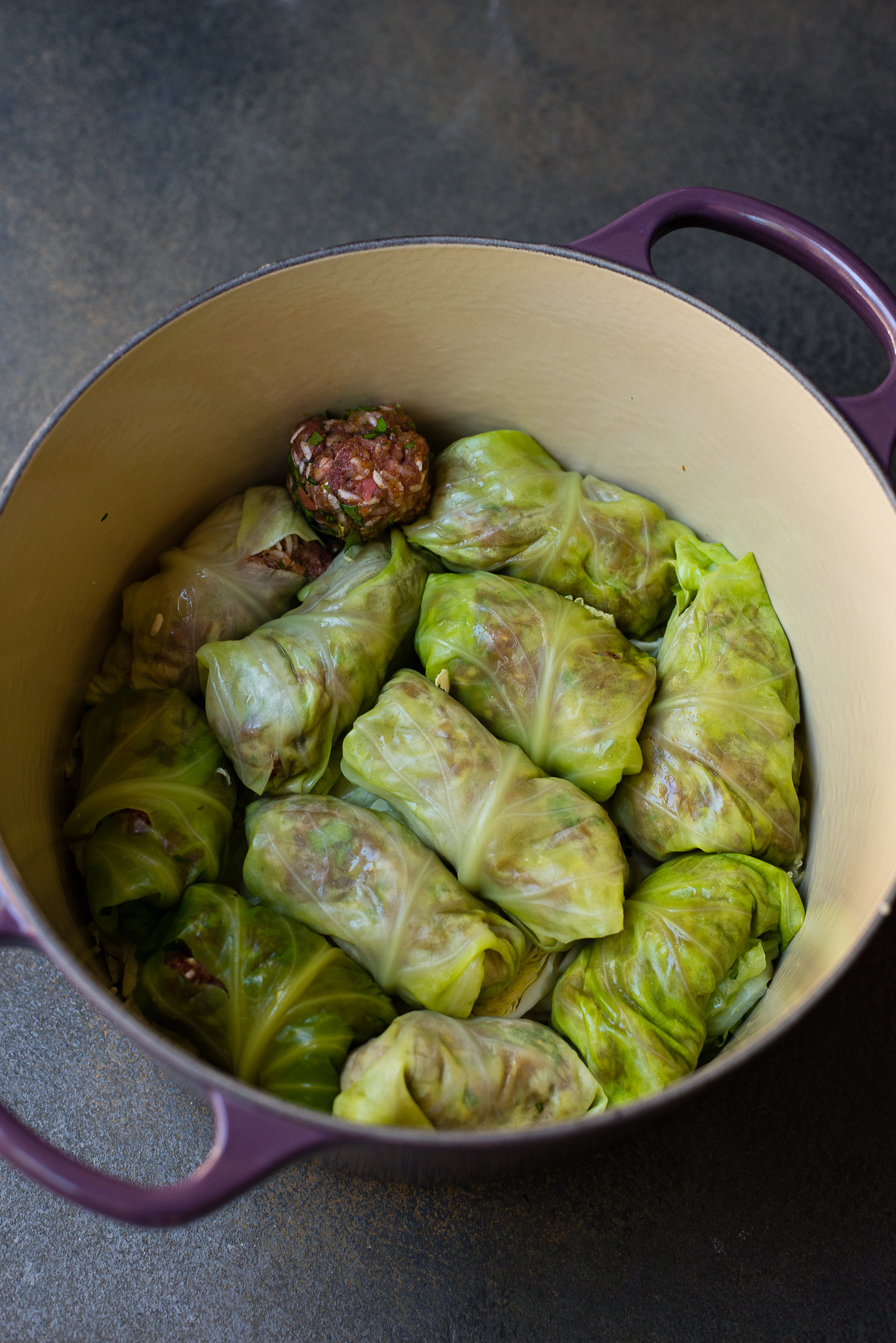 Sweet and sour cabbage rolls are snugly filled inside a dutch oven pot before adding the sweet and sour tomato sauce. 