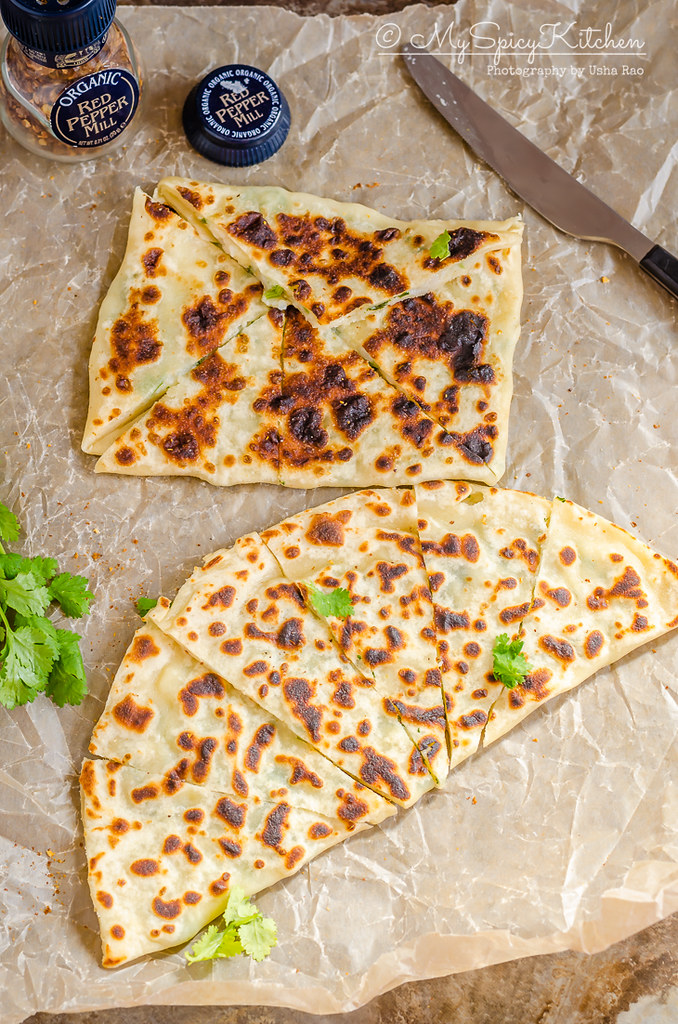 patatesli gozleme cut into wedges on a wax paper.