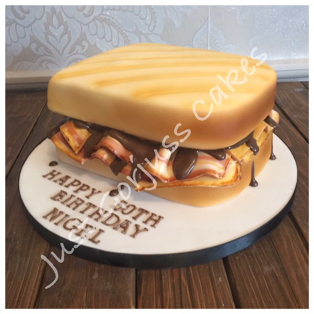This is a vanilla and raspberry sponge, decorated with fondant. The bacon is 100% fondant and the brown sauce is chocolate royal ice drip. By Donna Magness of Just Gorjuss Cakes