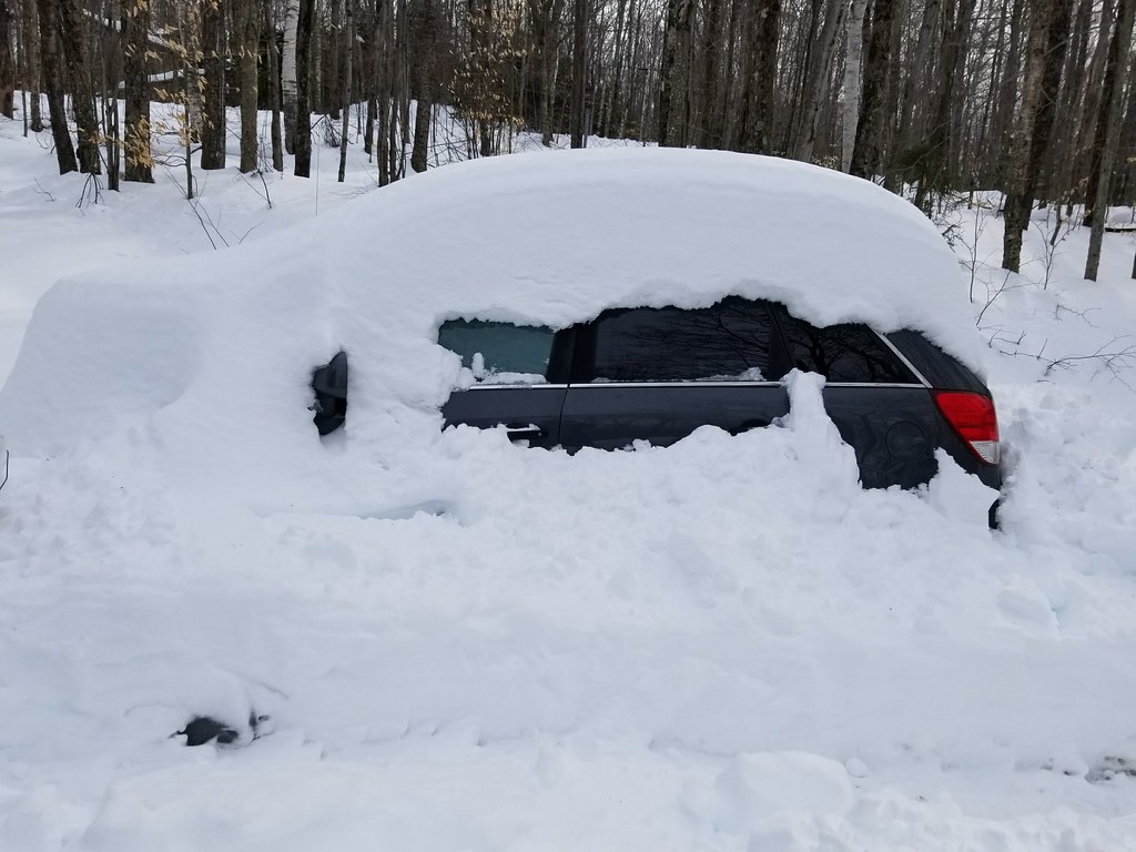 car emerging from snow