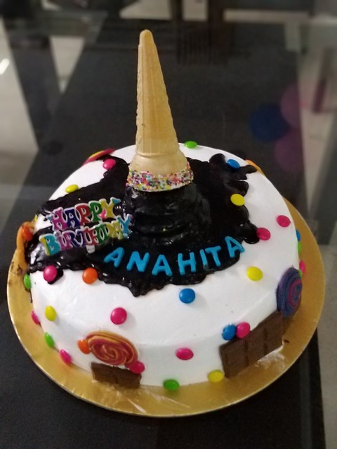 Melting Ice Cream on a Candy Cake. Chocolate ice cream melting on a candy filled colorful cake, lollipops are main attraction, love of every child on this Earth. By Simmi Jain of Simmi's Cake