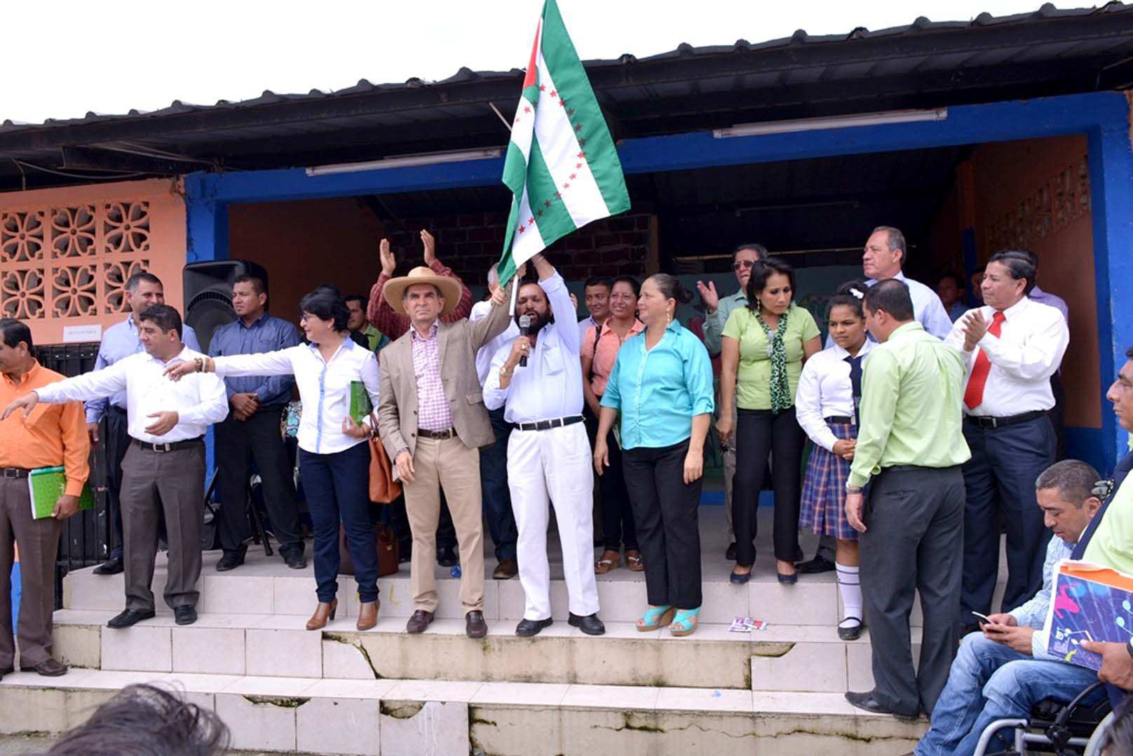 Clara Zambrano, viceprefecta, Mariano Zambrano, prefecto de Manabí y Hugo Cruz, alcalde de El Carmen, flamean bandera en El Paraiso la 14