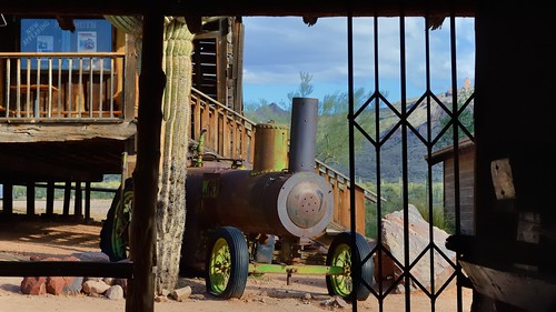 nikond3200 edk7 2013 us usa arizona pinalcounty apachejunction apachetrail superstitionmountains youngsberg goldfieldghosttown openairmuseum miningmuseum old derelict ruin wreck rusty rust vintage classic abandoned industrial mininginfrastructure mechanical machine disassembled steamtractionenginetractor saguaro cactus building metalgate tire tyre tree cloud sky landscape hill mountain countryside rural