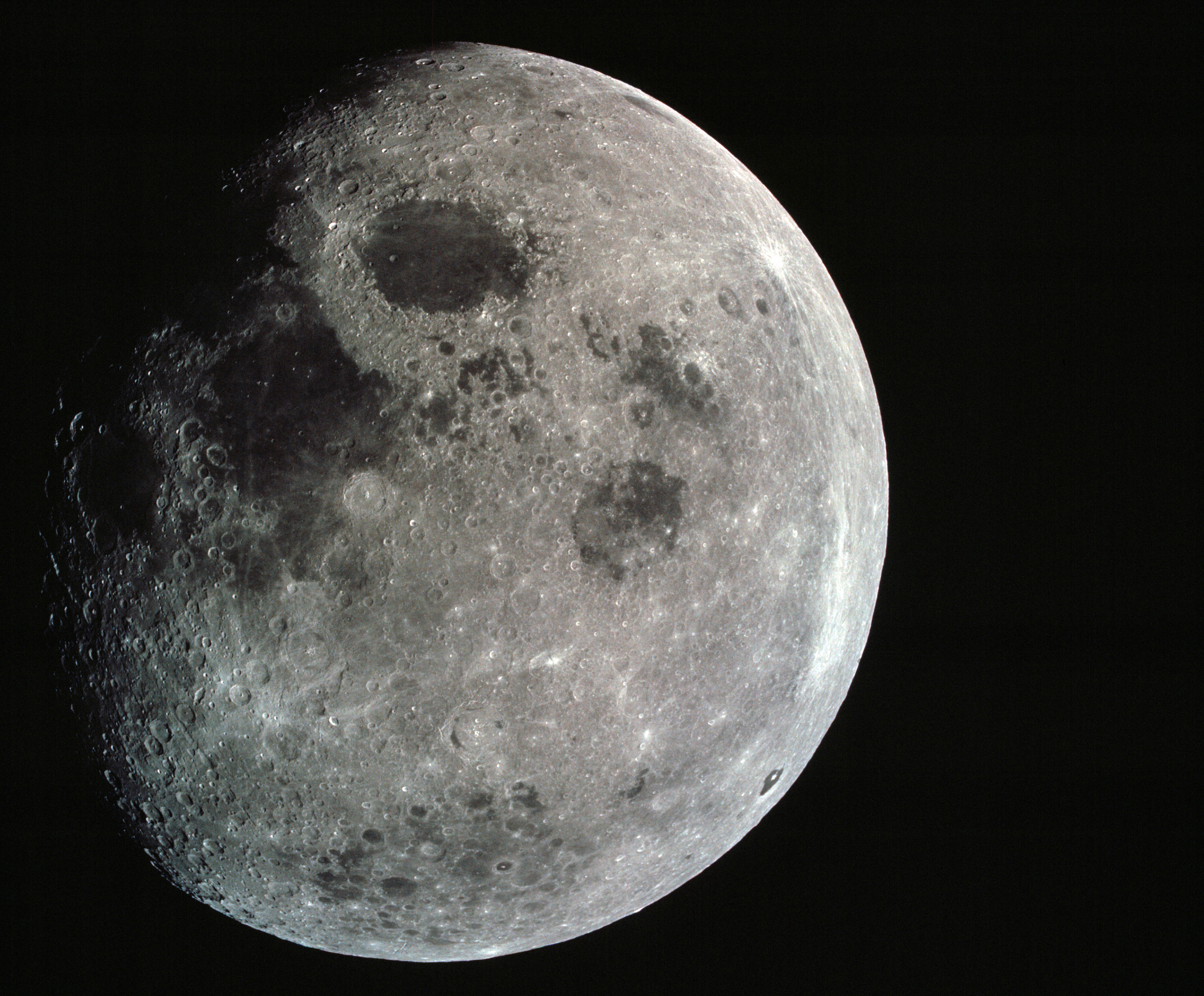 Photograph of a nearly full moon was taken from the Apollo 8 spacecraft at a point above 70 degrees east longitude. Mare Crisium, the circular, dark-colored area near the center, is near the eastern edge of the moon as viewed from Earth. Mare Nectaris is the circular mare near the terminator. The large, irregular maira are Tranquillitatis and Fecunditatis. The terminator at left side of picture crosses Mare Tranquillitatis and highlands to the south. Lunar farside features occupy most of the right half of the picture. The large, dark-colored crater Tsiolkovsky is near the limb at the lower right. Conspicuous bright rays radiate from two large craters, one to the north of Tsiolkovsky, the other near the limb in the upper half of the picture. These rayed craters were not conspicuous in Lunar Orbiter photography due to the low sun elevations when the Lunar Orbiter photography was made. The crater Langrenus is near the center of the picture at the eastern edge of Mare Fecunditatis. The lunar surface probably has less pronounced color that indicated by this print. 