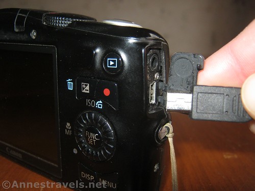 Plugging the small end of the USB cable into the camera to recharge the internal battery
