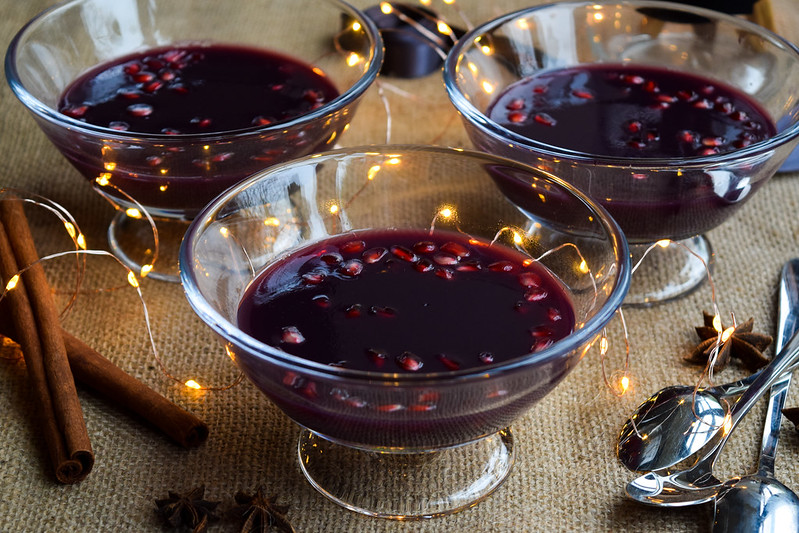 Mulled Wine Jellies in glass dishes studded with pomegranate seeds.