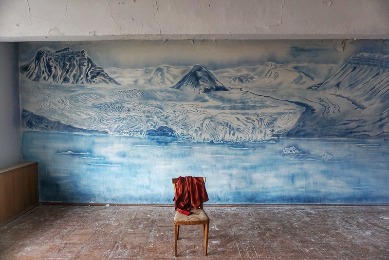 An empty chair and glacier mural in Pyramiden