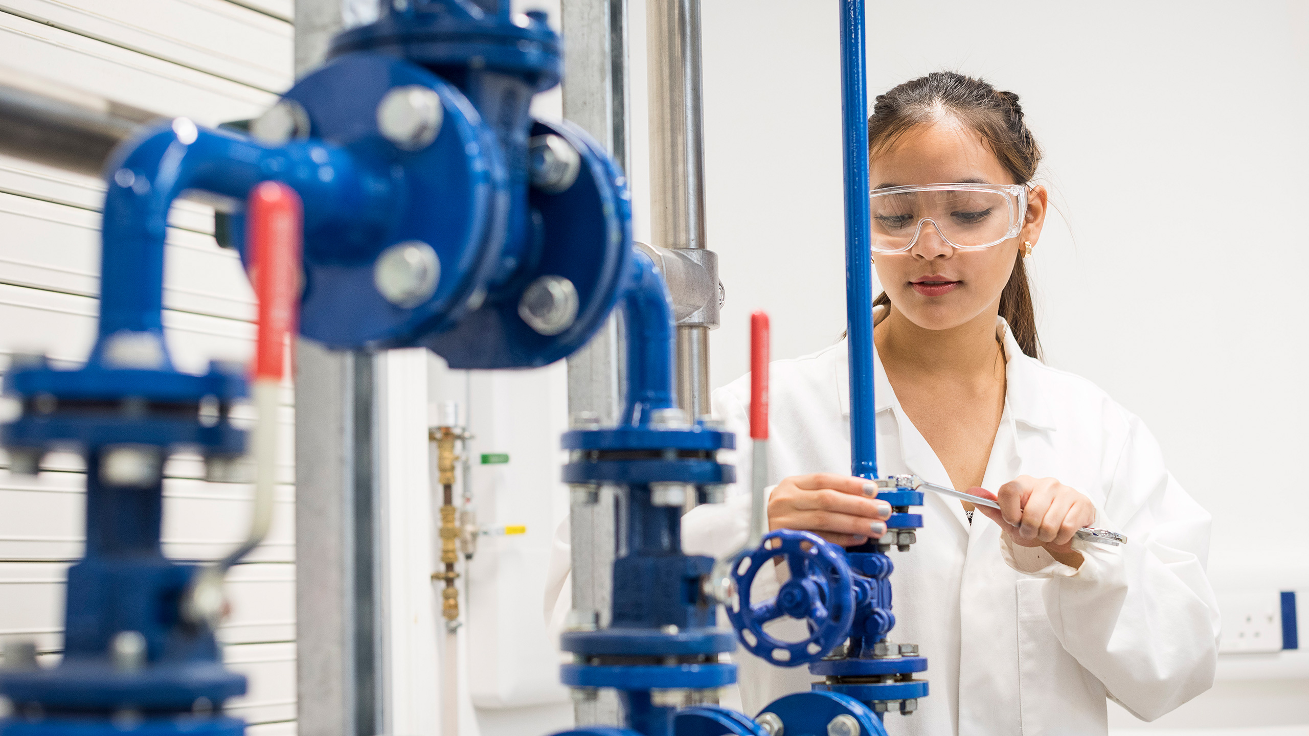 A student examines a rig in our chemical engineering lab.