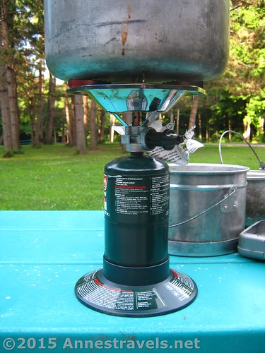 The Coleman Single Burner Bottle Top Propane Stove with a pot on top