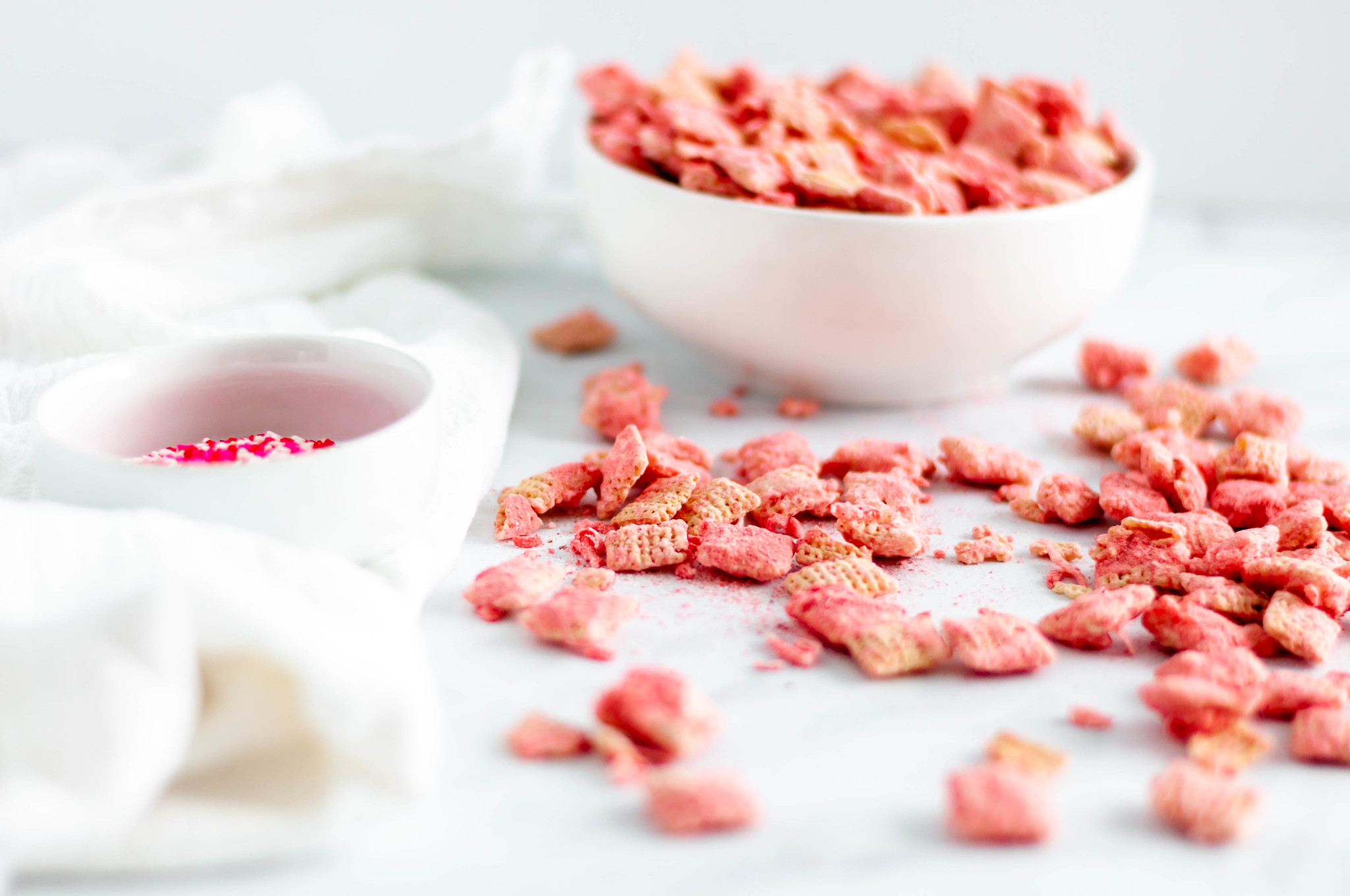 Make your Valentines Day festive with this Coconut Strawberry Puppy Chow. White chocolate, freeze dried strawberries & coconut are such a sweet combination.