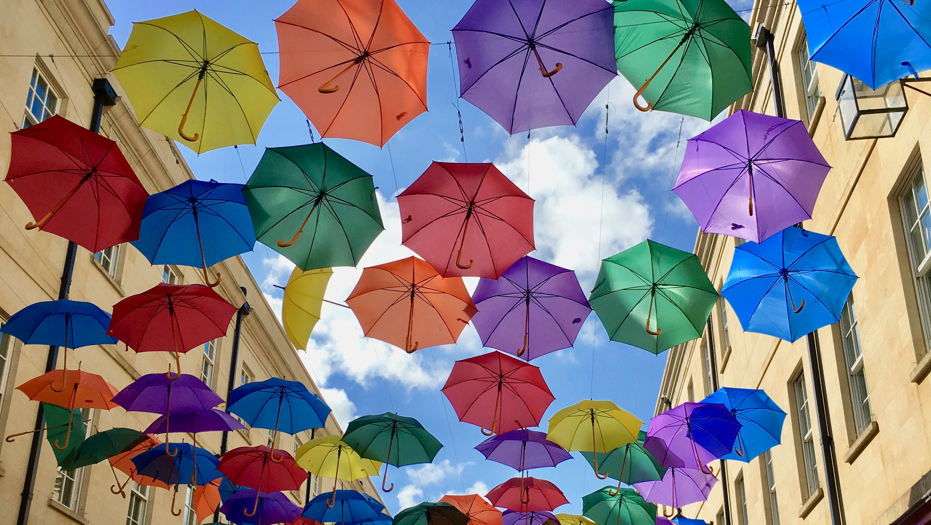 Brightly coloured umbrellas suspended in the sky in Bath city centre