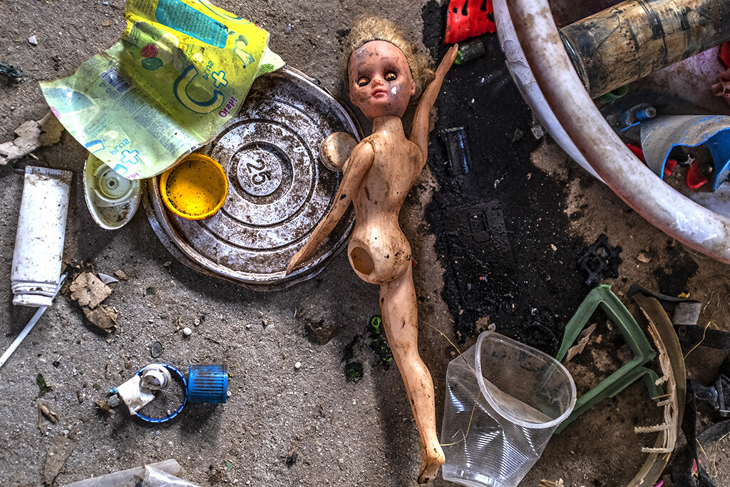 Broken doll among plastic garbage--Ea Kly