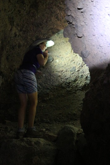 Vicki uses her headlamp as she navigates around a dark corner in Slot Canyon Two in Sidewinder Canyon
