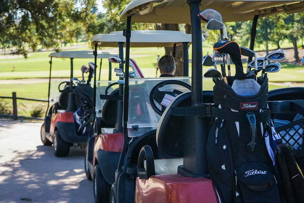 a row of three red golf buggies at Mijas Golf