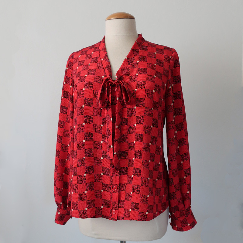 Red silk bow blouse on form front