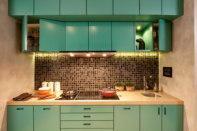 a teal kitchen with built-in appliances